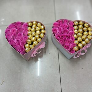 Heart-shaped pink roses and Ferrero Rocher chocolates in a box