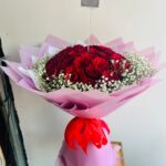 25 red roses with gypsophila wrapped in pink paper with red ribbon – romantic bouquet Dubai