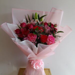 Puchsia Pink bouquet with 20 pink roses, a pink lily, and seasonal fillers wrapped in pink paper