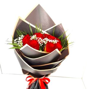 Romantic Night bouquet featuring 10 red roses with gypsophila, wrapped in black paper and red ribbon in Dubai