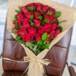 Love Story bouquet with 25 red roses and seasonal fillers wrapped in jute paper and raffia ribbon, Dubai florist