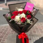 Love Elegant bouquet with red and white roses wrapped in black paper with a red ribbon in Dubai